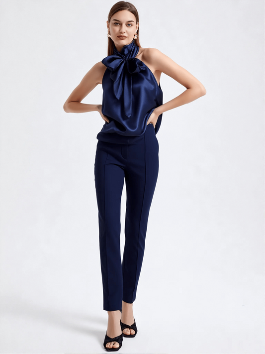 Modelka w granatowej jedwabnej bluzce ESCADA z dużą kokardą pod szyją