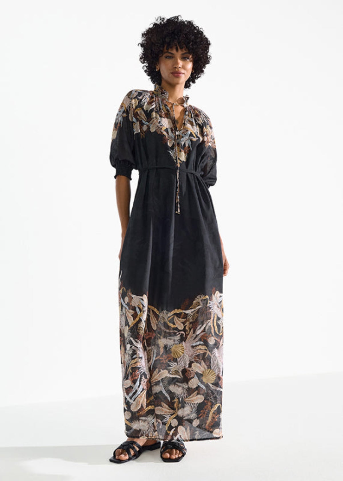 Modelka w czarnej sukience RIANI maxi w stylizacji wakacyjnej